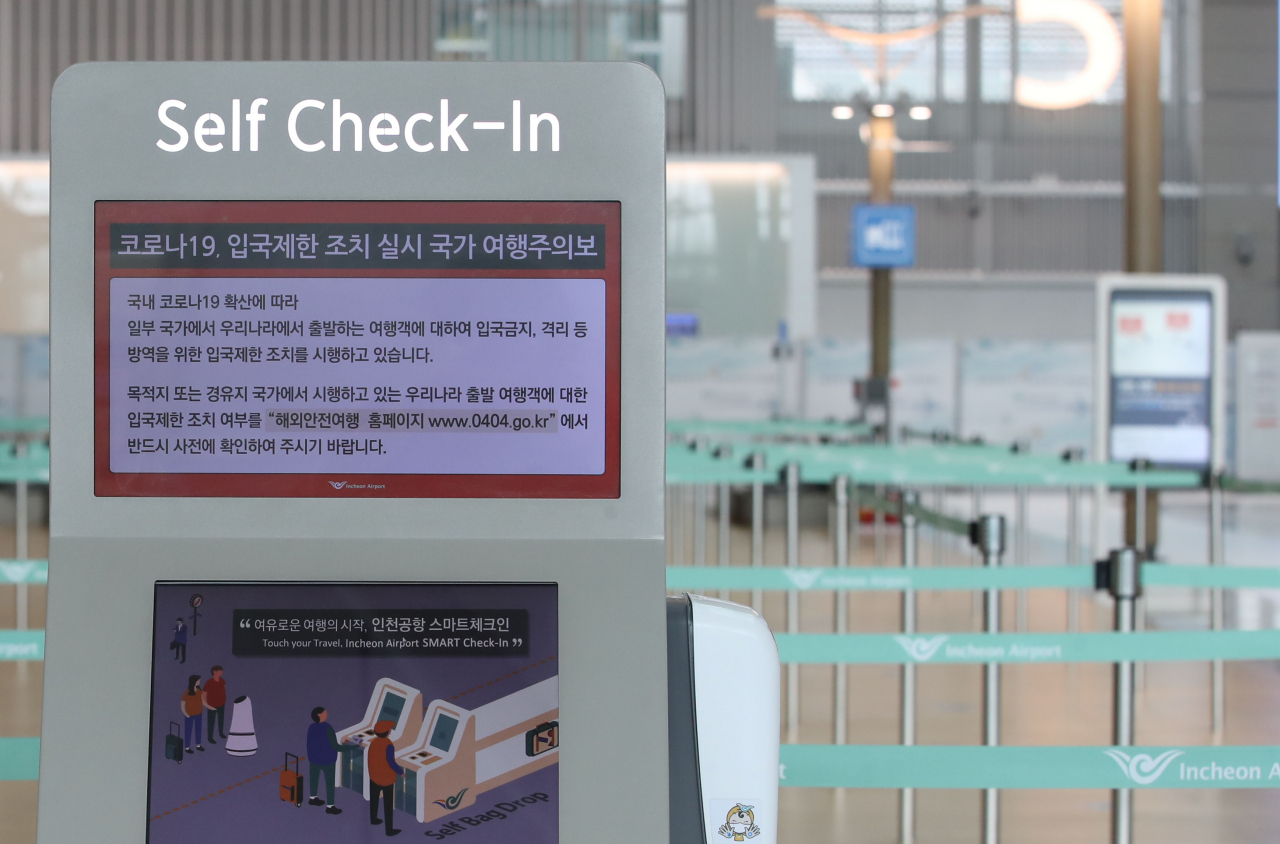 지난 23일 오전 인천국제공항 제1터미널 출국장 셀프 체크인 카운터 화면에 입국 제한 조치 실시 국가에 대한 여행주의보 안내문이 표시되고 있다. [연합]