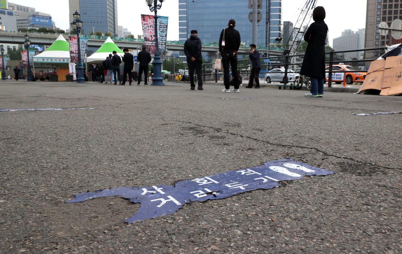 This photo shows people lining up to take a COVID-19 test at a testing booth in front of Seoul station on Wednesday. (Yonhap)