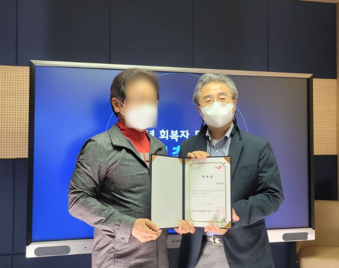 이홍식(오른쪽) 센터장이 위촉식을 갖고 한 지원가와 기념촬영을 하고 있다. [한국도박문제관리센터 제공]
