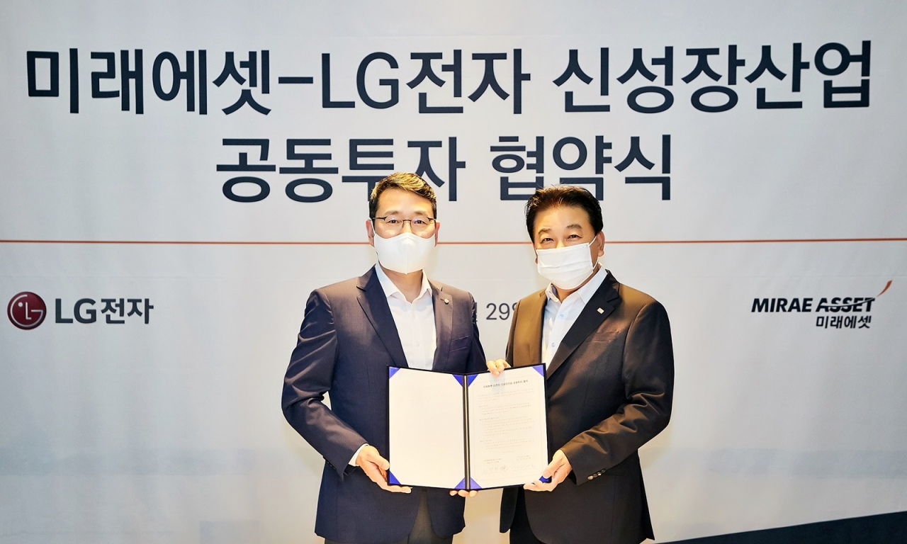 LG전자가 미래에셋그룹과 손잡고 신성장동력을 발굴하기 위해 국내외 유망 스타트업에 투자하는 1000억 원 규모의 신규 펀드를 조성한다. 지난 29일 서울 종로구 포시즌스호텔에서 열린 공동투자 협약식에서 LG전자 CSO 조주완 부사장(왼쪽), 미래에셋캐피탈 이만희 대표(오른쪽)가 기념촬영을 하고 있는 모습. [LG전자 제공]
