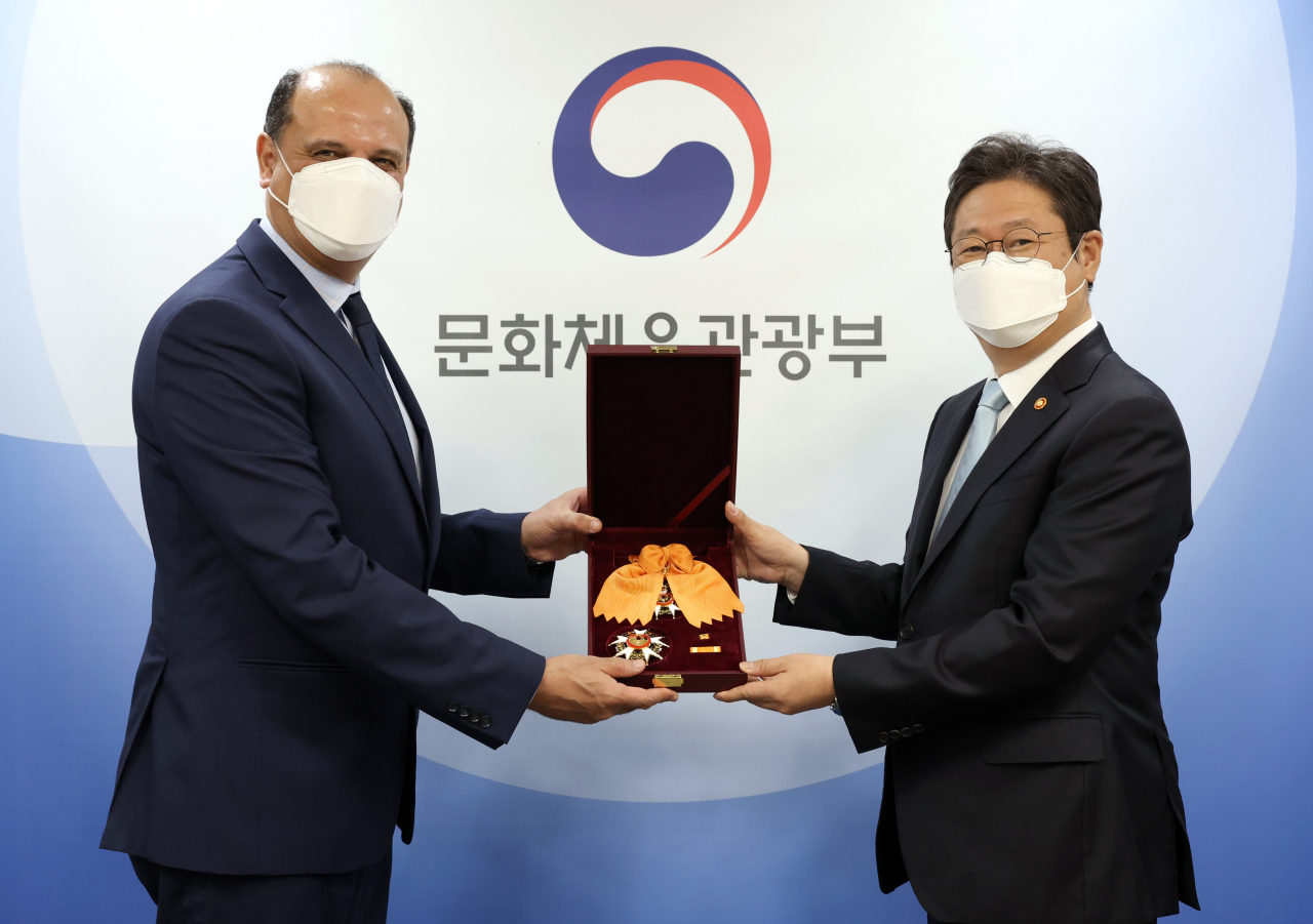 황희 문화체육관광부 장관이 30일 서울 용산구 문체부 저작권보호과 서울사무소 회의실에서고(故) 아흐메드 모하메드 풀리(Ahmed Mohamed Fouly) 회장에게 추서한 체육훈장 청룡장을 코로나19 상황으로 입국이 어려운 유가족을 대신해 하젬 모스타파 이브라힘 파미(Hazem Mostafa Ibrahim Fahmy) 주한 이집트 대사에게 전수한 뒤 기념촬영을 하고 있다. [문체부 제공]