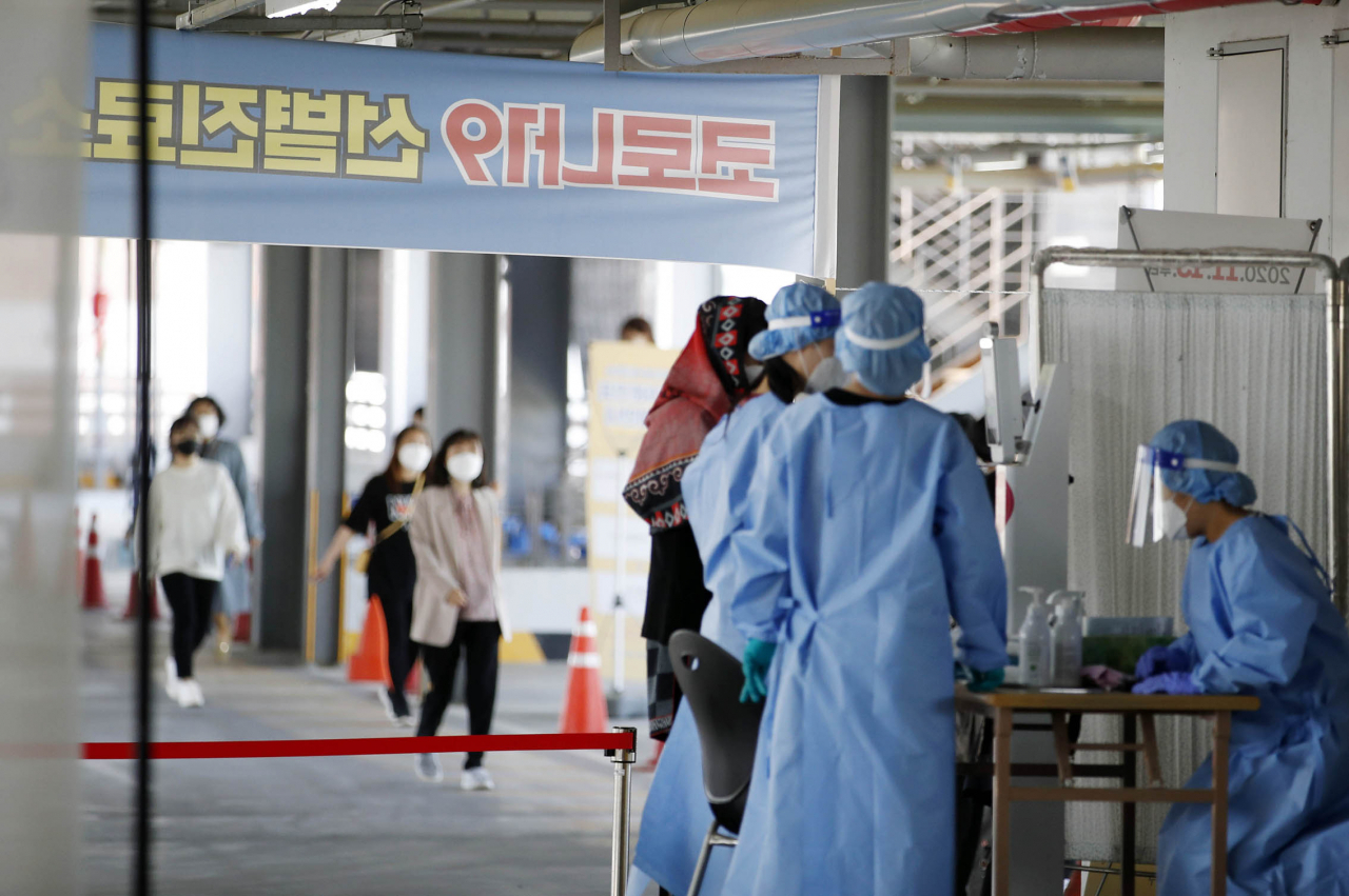지난달 30일 오후 광주 북구선별진료소에서 보건소 의료진이 신종 코로나바이러스 감염증(코로나19) 검체 대상자들의 문진을 도와주고 있다. [연합]