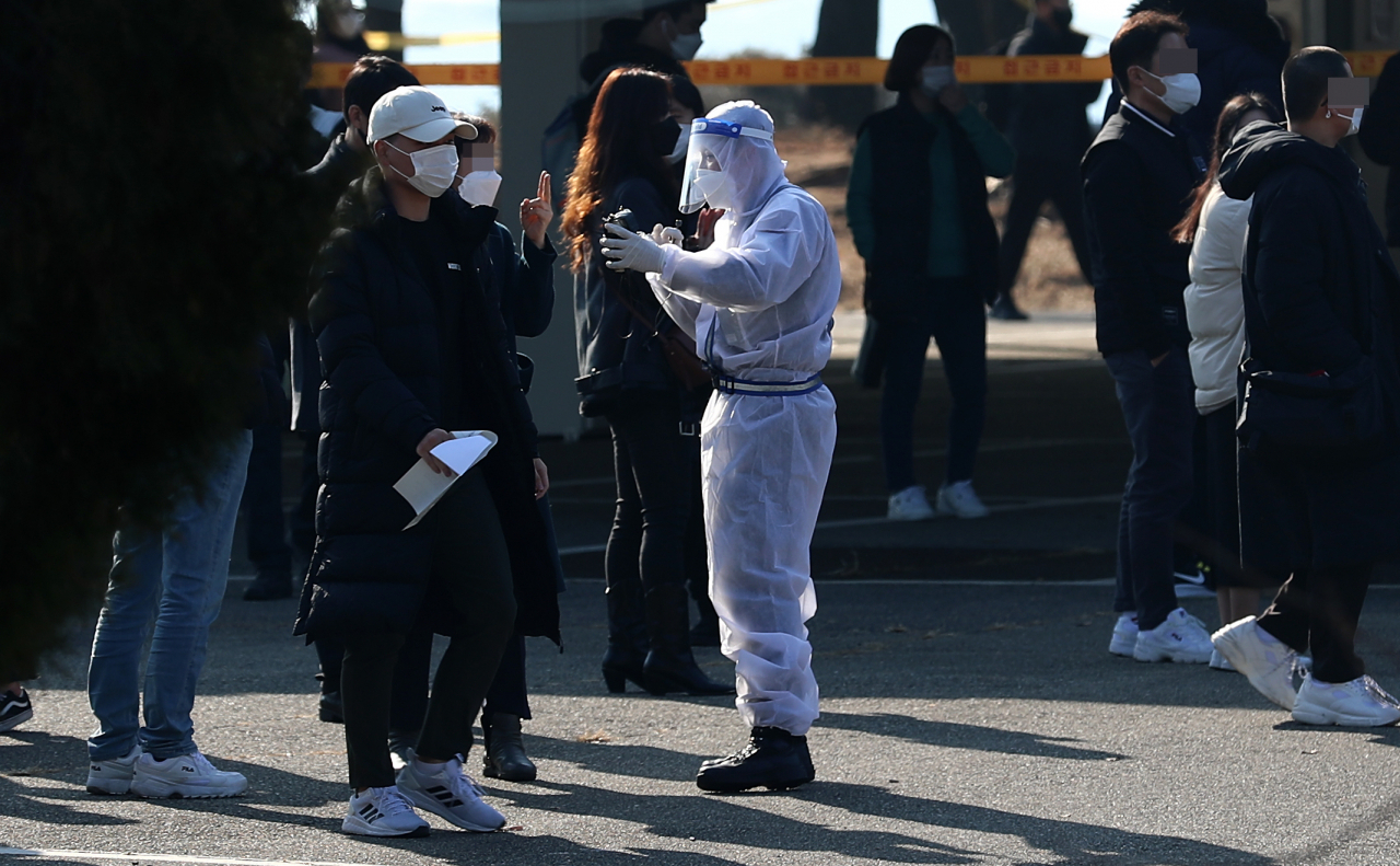 충남 논산 육군훈련소 입영심사대에서 입영장정을 안내하는 군 관계자들이 방호복과 마스크, 얼굴 가리개 등을 착용하고 있다. [연합]