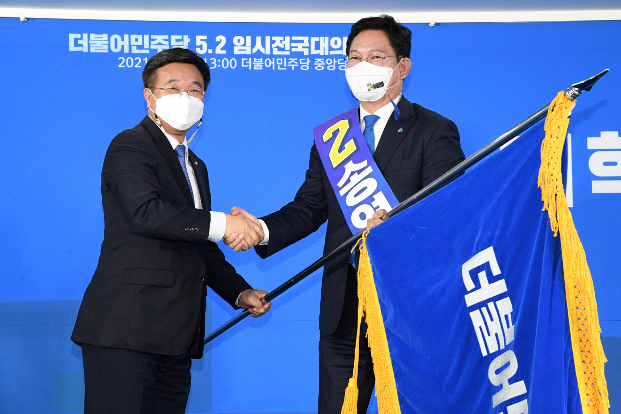 더불어민주당 새 대표로 선출된 송영길 의원(오른쪽)이 2일 서울 여의도 중앙당사에서 열린 임시전국대의원대회에서 윤호중 비상대책위원장으로부터 당기를 전달받고 있다. [연합]