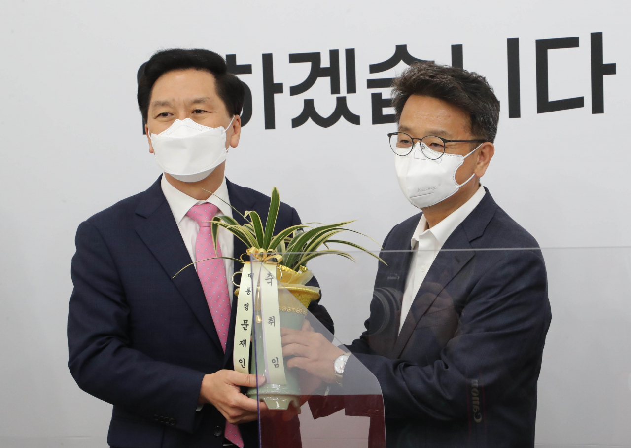 3일 오전 서울 여의도 국회를 방문한 이철희 청와대 정무수석(오른쪽)이 국민의힘 김기현 당 대표 권한대행 겸 원내대표를 예방해 문재인 대통령이 보낸 취임 축하난을 전달하고 있다 . [연합]