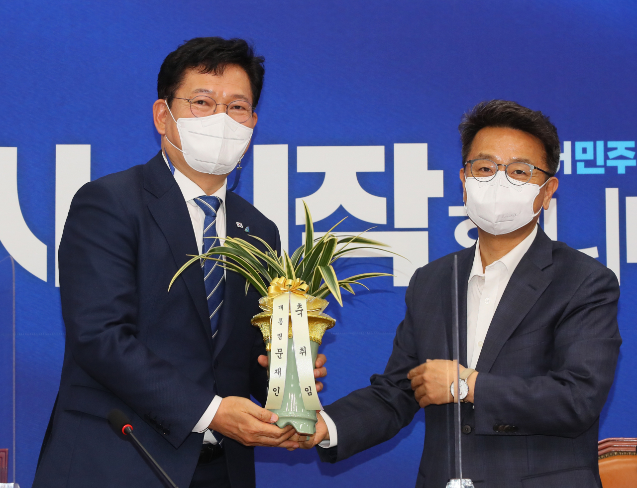 송영길 더불어민주당 대표(왼쪽)가 3일 서울 여의도 국회에서 이철희 청와대 정무수석으로 부터 문재인 대통령의 축하난을 전달받고 있다. 이상섭 기자/
