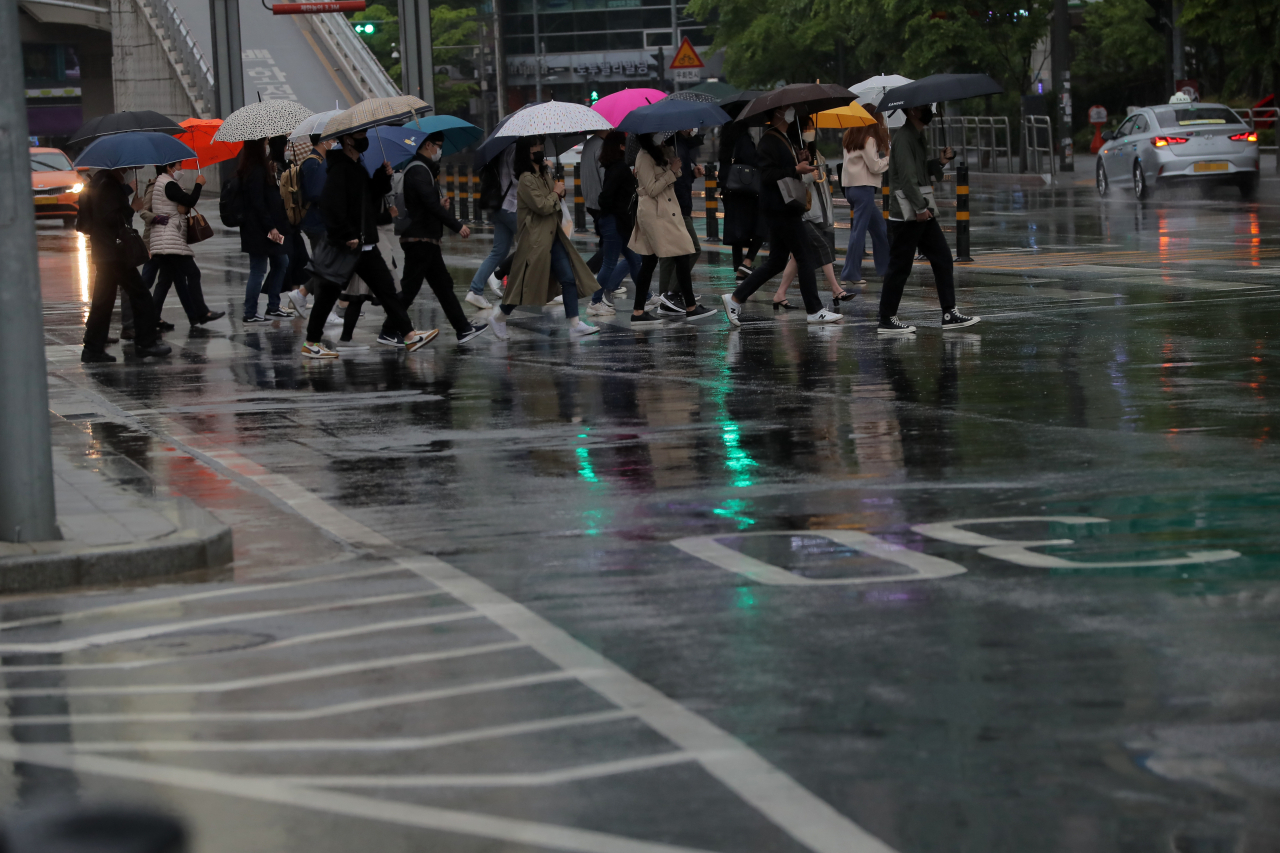 비가 내린 4일 오전 서울 용산구 용산역에서 우산을 쓴 시민들이 발걸음을 재촉하고 있다. [연합]