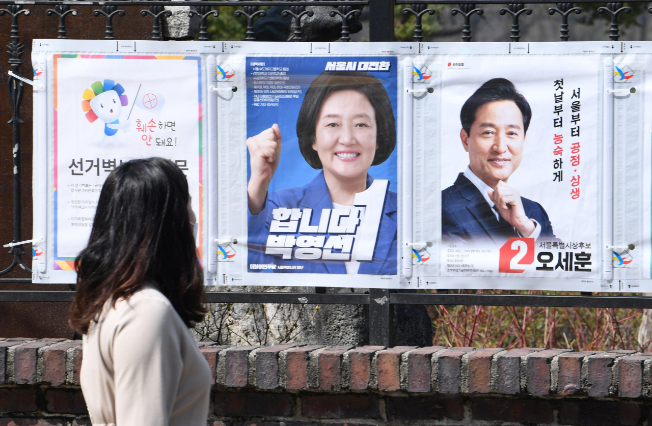 4·7 재보궐선거 공식 선거운동 첫날인 지난 3월 25일 오후 한 시민이 서울 종로구 예술가의 집 울타리에 부착된 선거 벽보를 살펴보고 있다.(사진은 기사 내용 과 관련없음) [연합]