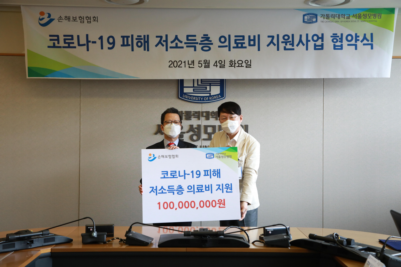 정지원 손해보험협회 회장(왼쪽)과 김용식 가톨릭대 서울성모병원 병원장이 4일 서울성모병원에서 '코로나19 피해 저소득층 의료비 지원사업' 협약을 맺은 후 기념촬영을 하고 있다.