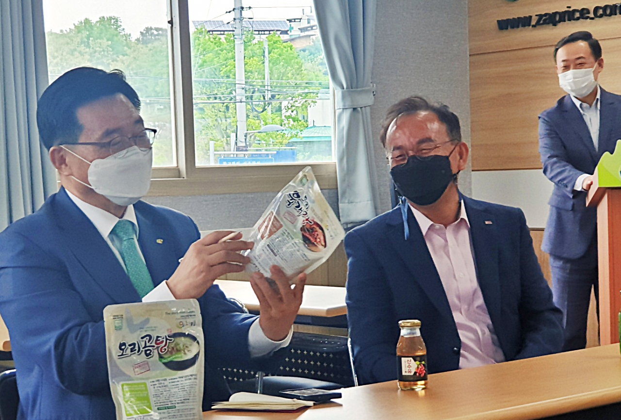 김춘진(왼쪽) 한국농수산식품유통공사(aT) 사장이 4일 전북 전주 두메산골 영농조합법인을 방문해 해당업체의 제품을 살펴보고 있다. [aT 제공]