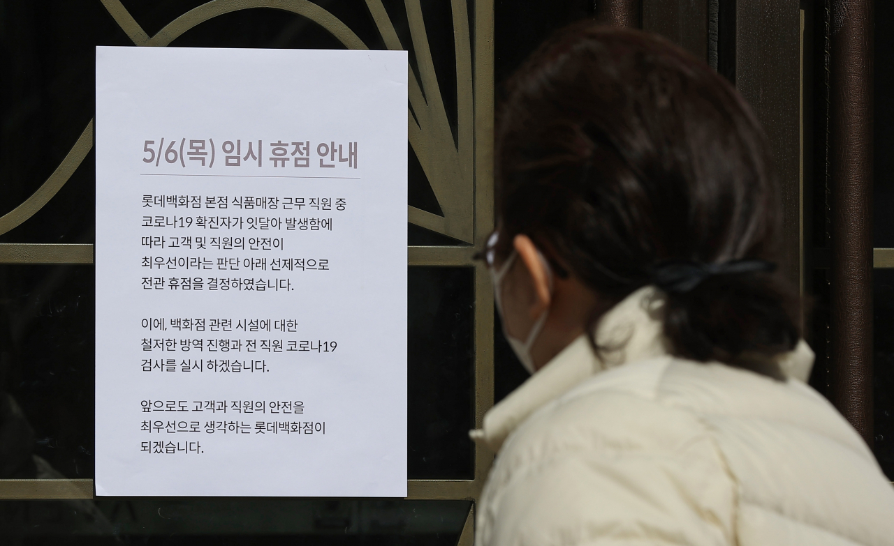 6일 오전 서울 중구 롯데백화점 본점에서 한 시민이 ‘임시 휴점’ 안내문을 읽고 있다. 롯데백화점은 6일까지 식품관만 임시 휴업할 예정이었으나 고객안전을 위해 선제적으로 본점 전체와 인근 에비뉴엘 영플라자까지 6일 휴점을 실시한다. 또한 롯데백화점은 협력업체 직원을 포함한 본점 근무자 약 3700명에 대한 코로나19 검사를 진행한다고 밝혔다. [연합]