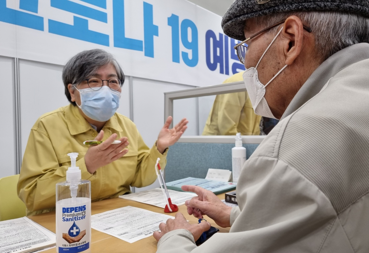 정은경 중앙방역대책본부장(왼쪽)이 8일 세종시 아름동 예방접종센터를 찾아 코로나19 백신 접종 전 문진을 하는 등 자원봉사를 하고 있다.[연합]