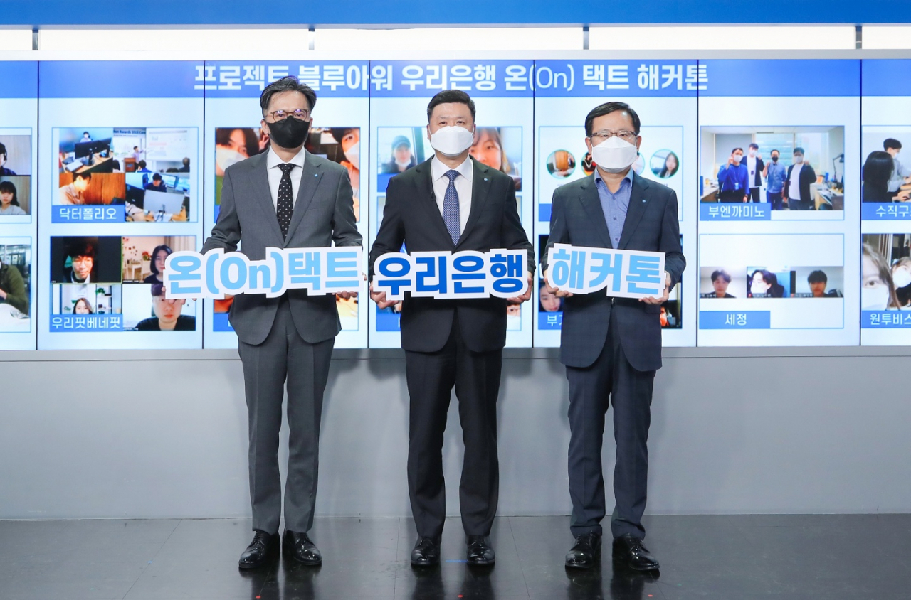 우리은행은 지난 7일 서울시 중구 소재 우리은행 본점에서 ‘온(On)택트 해커톤 대회’ 시상식을 비대면으로 개최했다. 권광석(가운데) 우리은행장과, 조병규(오른쪽) 경영기획그룹장, 황원철(왼쪽) 디지털금융그룹장이 기념촬영을 하고 있다. [우리은행 제공]