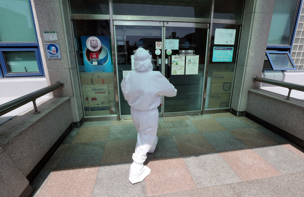 9일 오전 전남 여수시의 한 요양병원에서 신종 코로나바이러스 감염증(코로나19) 집단 감염이 발생해 동일집단(코호트) 격리 조치가 이뤄진 가운데 방역 당국 관계자가 병원에 들어서고 있다. 이 요양병원에서는 8일 요양보호사가 확진 판정을 받은 이후 환자 10명이 추가로 감염됐다. 연합뉴스