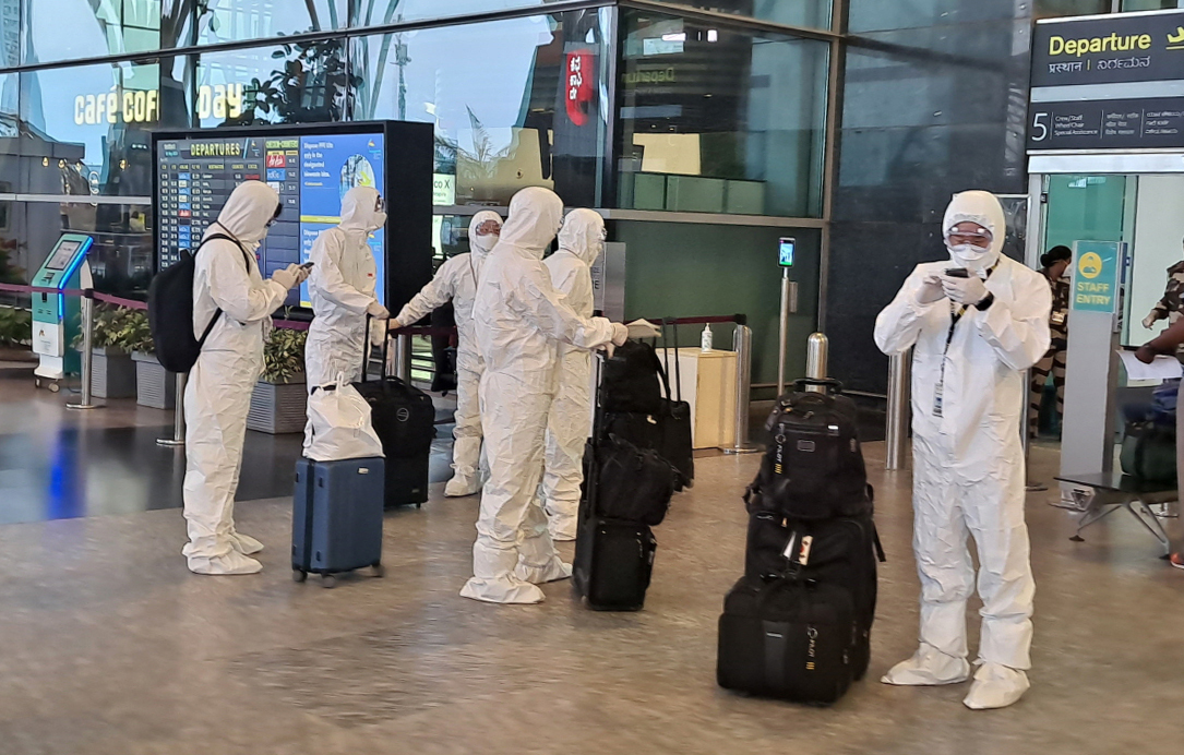 Air cabin crew members on chartered flight carrying South Korean citizens from virus-hit India are dressed in hazmat suits. (Yonhap)