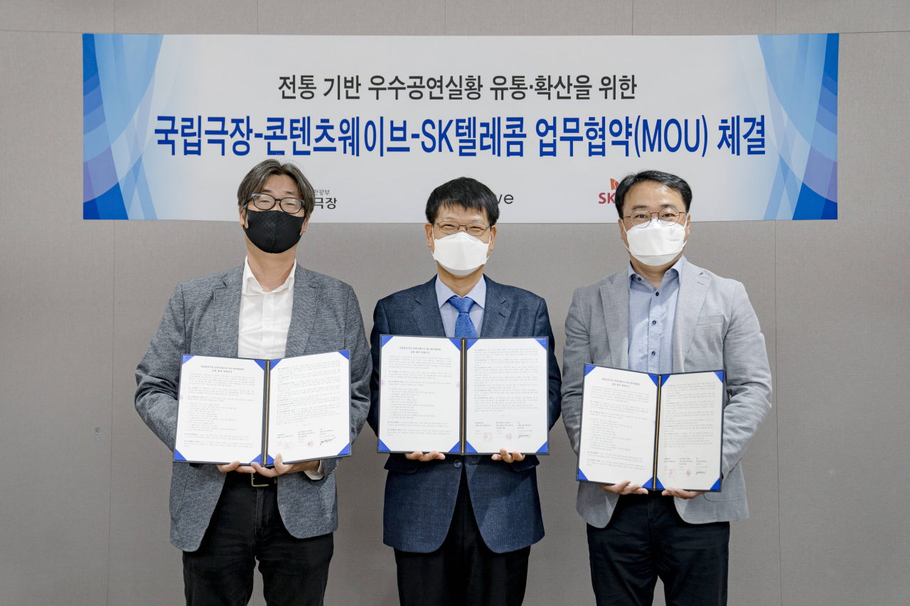 SK텔레콤은 국립중앙극장, 콘텐츠웨이브와 전통 공연을 5G 기반의 멀티뷰 영상 콘텐츠로 제작해 방송하는 내용의 양해각서(MoU)를 체결했다고 밝혔다. 사진은 체결식에 참석한 김창현 SK텔레콤 미디어서비스혁신팀장(사진 오른쪽)과 강성구 국립극장 공연전시부장(중앙)과 이희주 콘텐츠웨이브 대외협력실장(사진 왼쪽)의 모습. [SK텔레콤 제공]