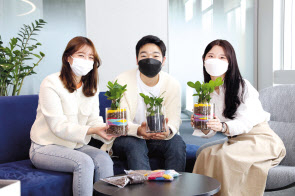 현대글로비스 직원들이 지역사회 홀몸 어르신을 위해 준비한 반려식물을 소개하고 있다. [현대글로비스 제공]
