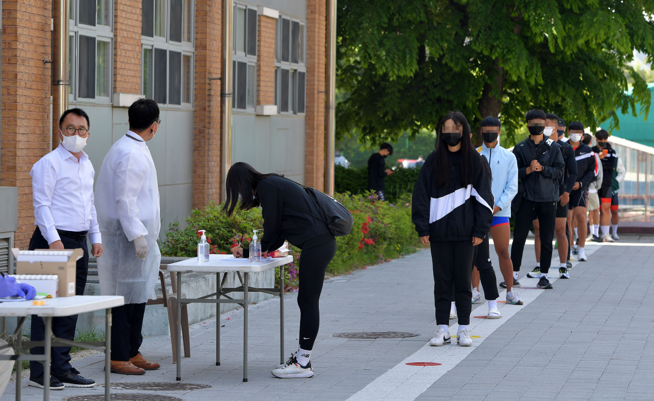 지난 3일 서울 송파구 서울체육중고등학교에 설치된 코로나19 이동식 PCR 검사소 앞에 학생 및 교직원들이 검사를 받기 위해 줄을 서 있다. [연합]