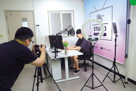 포스코ICT가 운영하고있는 유튜브 크리에이터 양성과정에 참여하고 있는 참가자가 스튜디오에서 영상제작을 실습하고 있다. [포스코ICT제공]