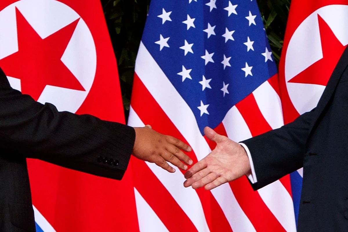 US President Donald Trump (right) reaches to shake hands with North Korea leader Kim Jong-un at the Capella resort on Sentosa Island in Singapore in this 2018 file photo. (AP-Yonhap)
