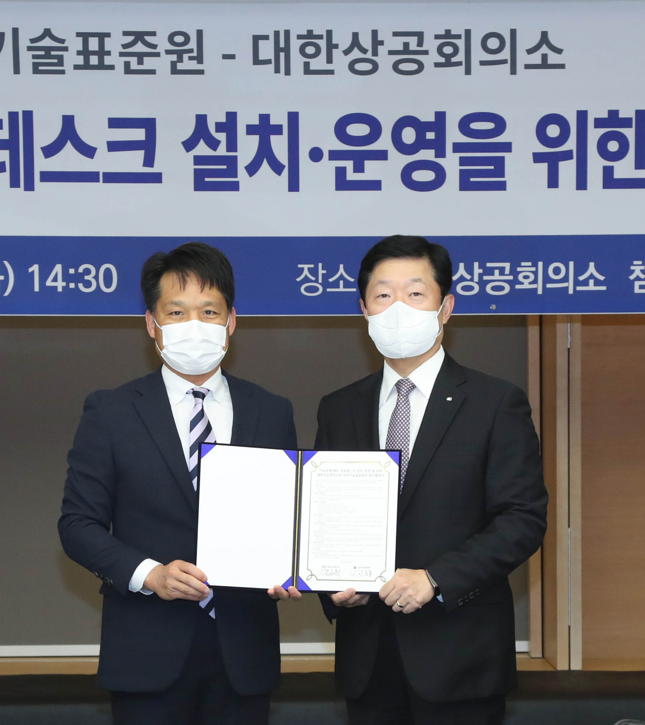 우태희 대한상의 상근부회장(사진 오른쪽)과 이상훈 국가기술표준원 원장(왼쪽)이 협약서에 서명 후 기념촬영을 하고 있다. [대한상의 제공]