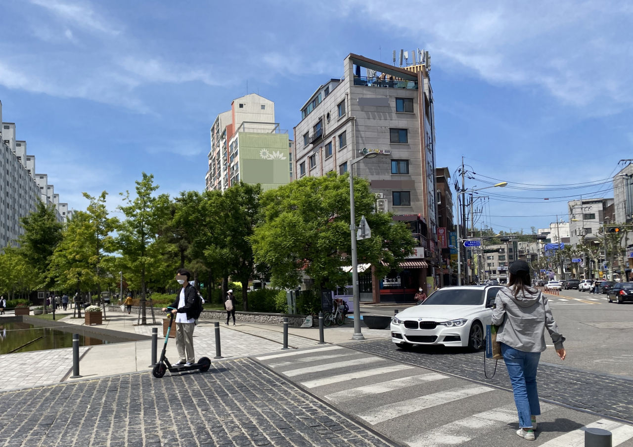 지난 11일 서울 마포구 경의선숲길 공원을 지나는 차도로 개인형이동장치(PM)과 자동차, 보행자가 동시에 지나고 있다. 자전거와 자동차와 함께 쓰는 도로로 PM이 차도 바깥을 따라 지나갈 수 있으나 운전자가 안전모를 착용하지 않았다. 13일부터 PM 이용 시 이처럼 보호장구를 이용하지 않으면 범칙금 3만원이 부과된다. 주소현 기자/addressh@heraldcorp.com