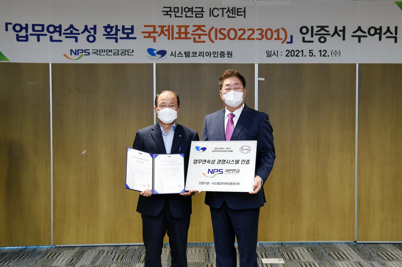 국민연금공단 김청태 디지털혁신본부장(왼쪽)이 공단 본부에서 12일 진행된 ‘업무연속성 경영시스템(ISO22301) 인증식’에서 인증서를 받고 시스템코리아인증원 김철 원장과 함께 기념촬영을 하고 있다. [국민연금공단 제공]