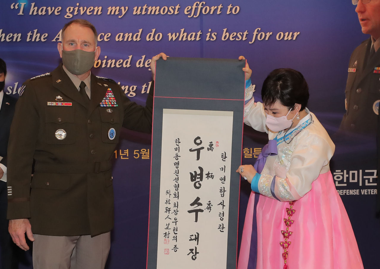 이임을 앞둔 로버트 에이브럼스 주한미군사령관 겸 한미연합사령관이 13일 한미동맹재단 주관으로 열린 환송행사에서 우현의 한미동맹친선협회장으로부터 한글 이름 ‘우병수’가 새겨진 족자를 선물 받고 있다. 성은 에이브럼스의 ‘ㅇ’, ‘병(柄)’은 근본의 의미, ‘수(秀)’는 대한민국 안보와 한미동맹에 크게 기여했다는 의미를 담았으며 본관은 미군기지가 있는 평택으로 정했다. [연합]