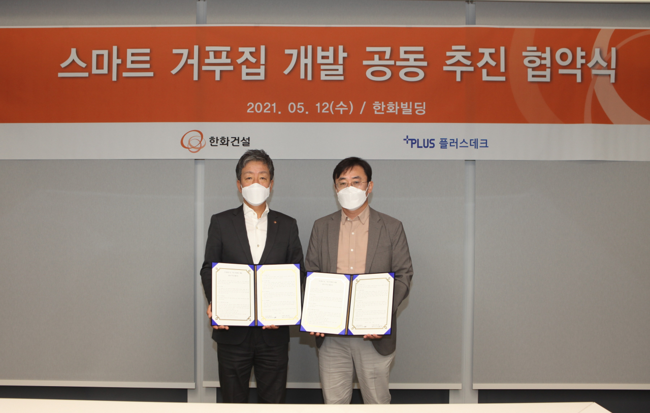 윤용상 한화건설 건축사업본부장(왼쪽)과 김덕진 플러스데크 대표가 지난 12일 ‘스마트 거푸집 개발 공동 추진 협약’을 체결한 뒤 기념촬영을 하고 있다. [한화건설 제공]