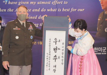 이임을 앞둔 로버트 에이브럼스 주한미군사령관 이 13일 한미동맹재단 주관으로 열린 환송행사에서 우현의 한미동맹친선협회장으로부터 한글 이름 ‘우병수’가 새겨진 족자를 선물 받고 있다. [연합]