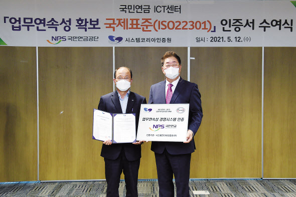국민연금공단 김청태 디지털혁신본부장(왼쪽)이 공단 본부에서 12일 진행된 ‘업무연속성 경영시스템(ISO22301) 인증식’에서 시스템코리아인증원 김철 원장과 함께 기념촬영을 하고 있다. [국민연금공단 제공]