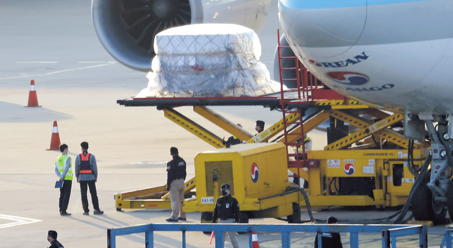 13일 인천국제공항 화물터미널 직원들이 백신 공동구매 국제 프로젝트인 ‘코백스 퍼실리티’를 통해 확보한 아스트라제네카사의 신종 코로나바이러스 감염증(코로나19) 백신 83만5000회분(2회 접종 기준 41만7500명분)을 항공기에서 내리고 있다. [연합]
