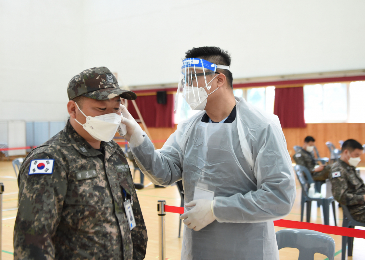 30세 이상 군 장병을 대상으로 한 코로나19 백신 접종이 시작된 지난 4월 28일 해군 잠수함사령부 장병이 해군 잠수함사령부 당경관에 설치된 접종소에서 백신 접종 전 체온 측정을 하고 있다. [국방부 제공]