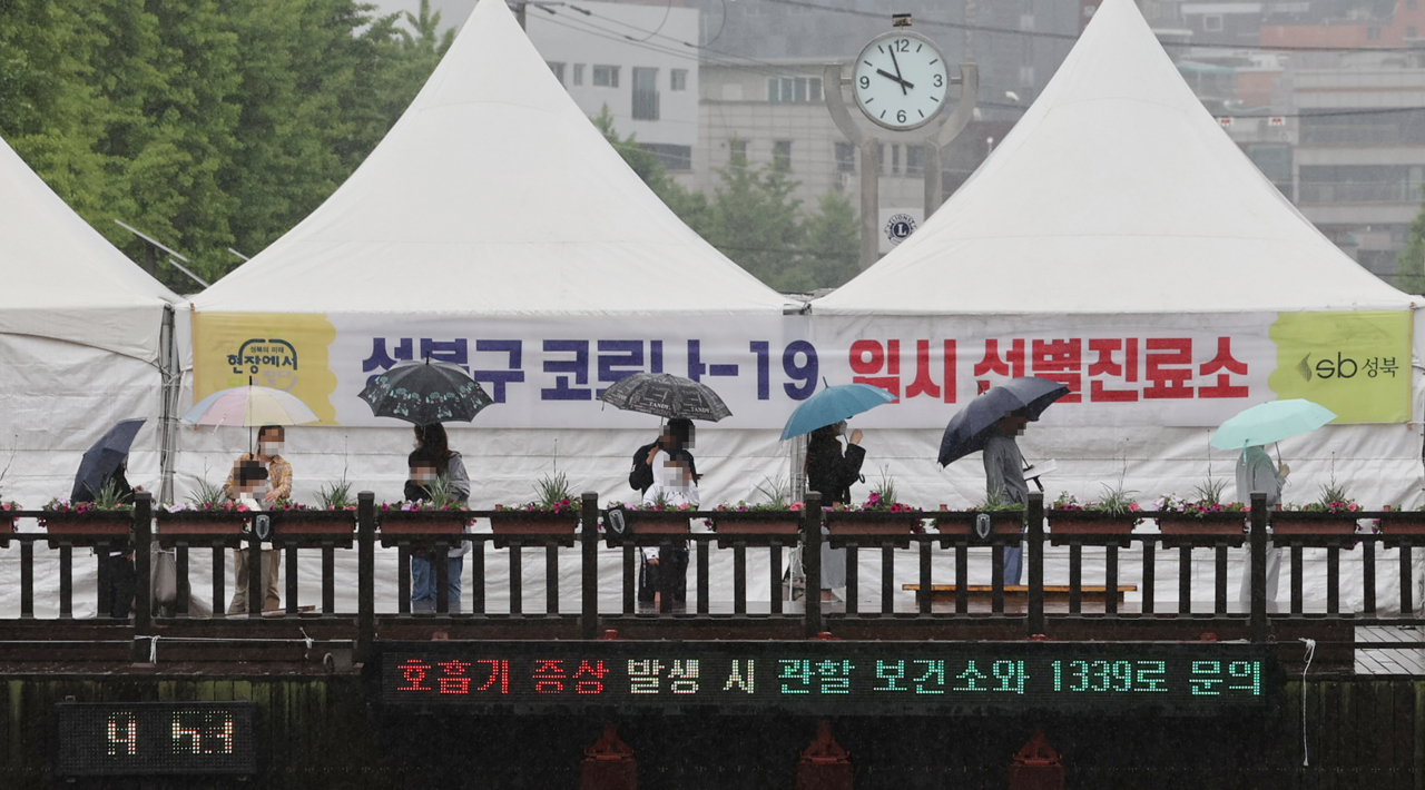 지난 15일 하루 동안 서울에서 발생한 신종 코로나바이러스 감염증(코로나19) 신규 확진자 수가 213명이라고 서울시가 16일 밝혔다. 사진은 16일 오전 서울 성북구청 앞에 설치된 임시선별진료소에서 시민들이 우산을 쓰고 검사를 위해 대기해 있다. [연합]