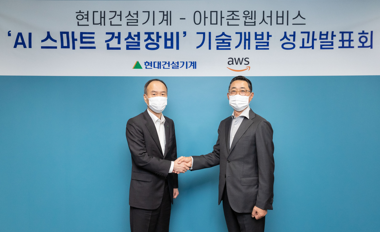 17일 서울 강남 AWS 코리아 본사(역삼동 GS타워)에서 열린 '현대건설기계-아마존웹서비스 AI 스마트 건설장비 기술개발 성과발표회'에서 참석자들이 기념사진을 촬영하고 있다. 사진 왼쪽부터 현대건설기계 윤영철 R&D 본부장, AWS코리아 함기호 대표. [현대건설기계 제공]