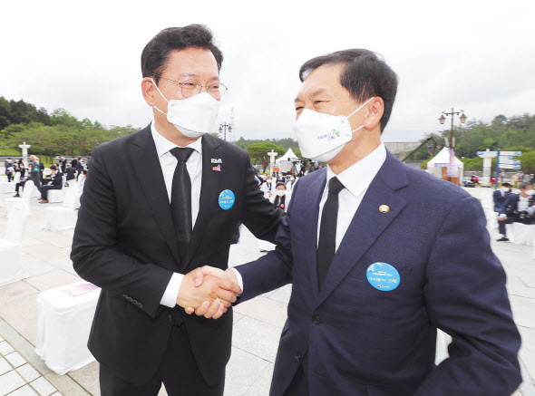 송영길 더불어민주당 대표(왼쪽)와 김기현 국민의힘 대표 권한대행 겸 원내대표가 18일 오전 광주 북구 국립 5·18 민주묘지에서 열린 제41주년 5·18 민주화운동 기념식에서 만나 악수하고 있다. [연합]