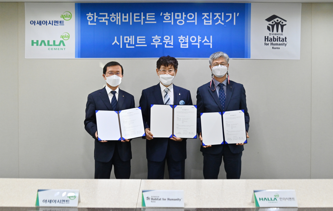 양승조(왼쪽부터) 아세아시멘트 전무, 윤형주 한국해비타트 이사장, 황석용 한라시멘트 대표가 ‘희망의 집짓기’ 후원 협약식 이후 기념촬영을 하고 있다. [한라시멘트 제공]