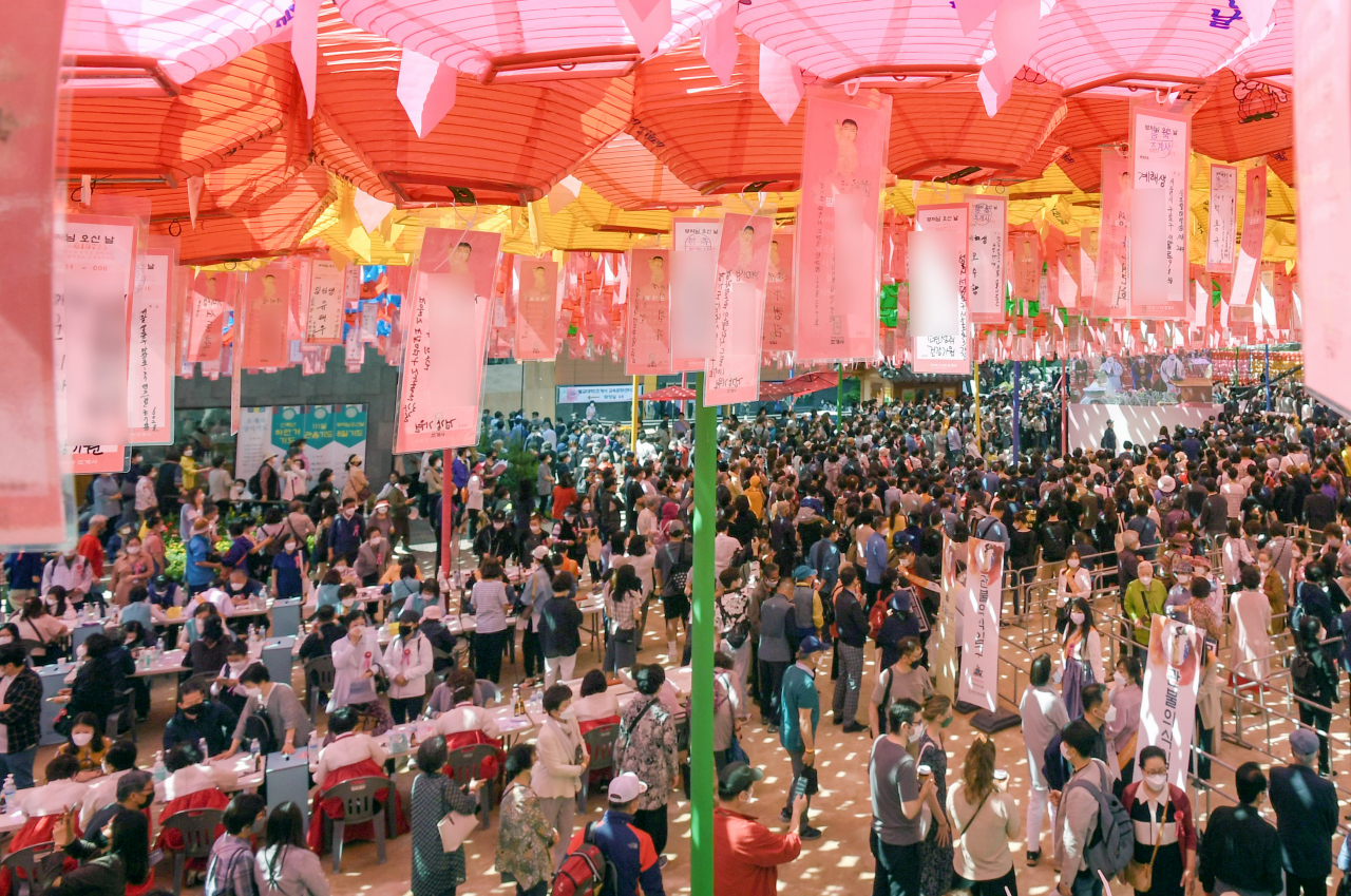 19일 서울 종로구 조계사에서 불기 2565년 부처님오신날 봉축법요식을 보기 위해 많은 신도들이 연등 아래를 오가고 있다. 연합뉴스