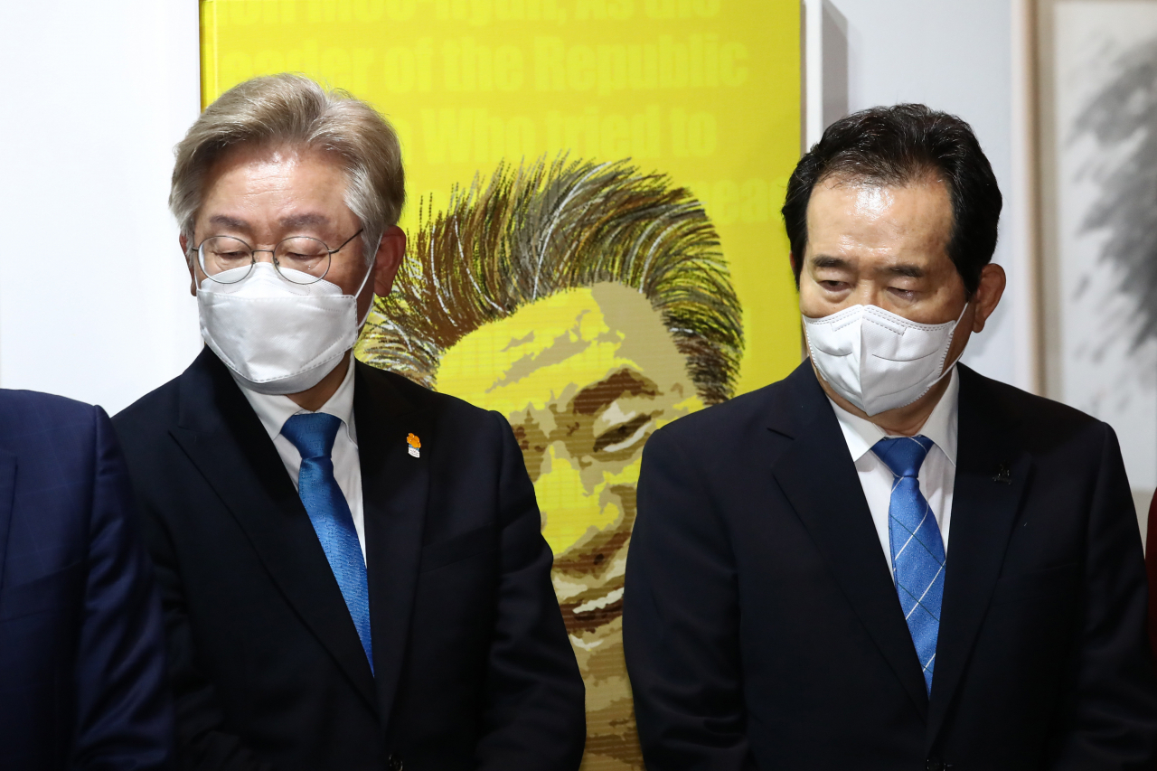 정세균 전 국무총리(오른쪽)와 이재명 경기도지사가 19일 서울 종로구 인사동 마루아트센터에서 열린 노무현 서거 12주기 추모전시에 참석해 권도경 작가의 캘리그라피 퍼포먼스를 보고 있다. [연합]