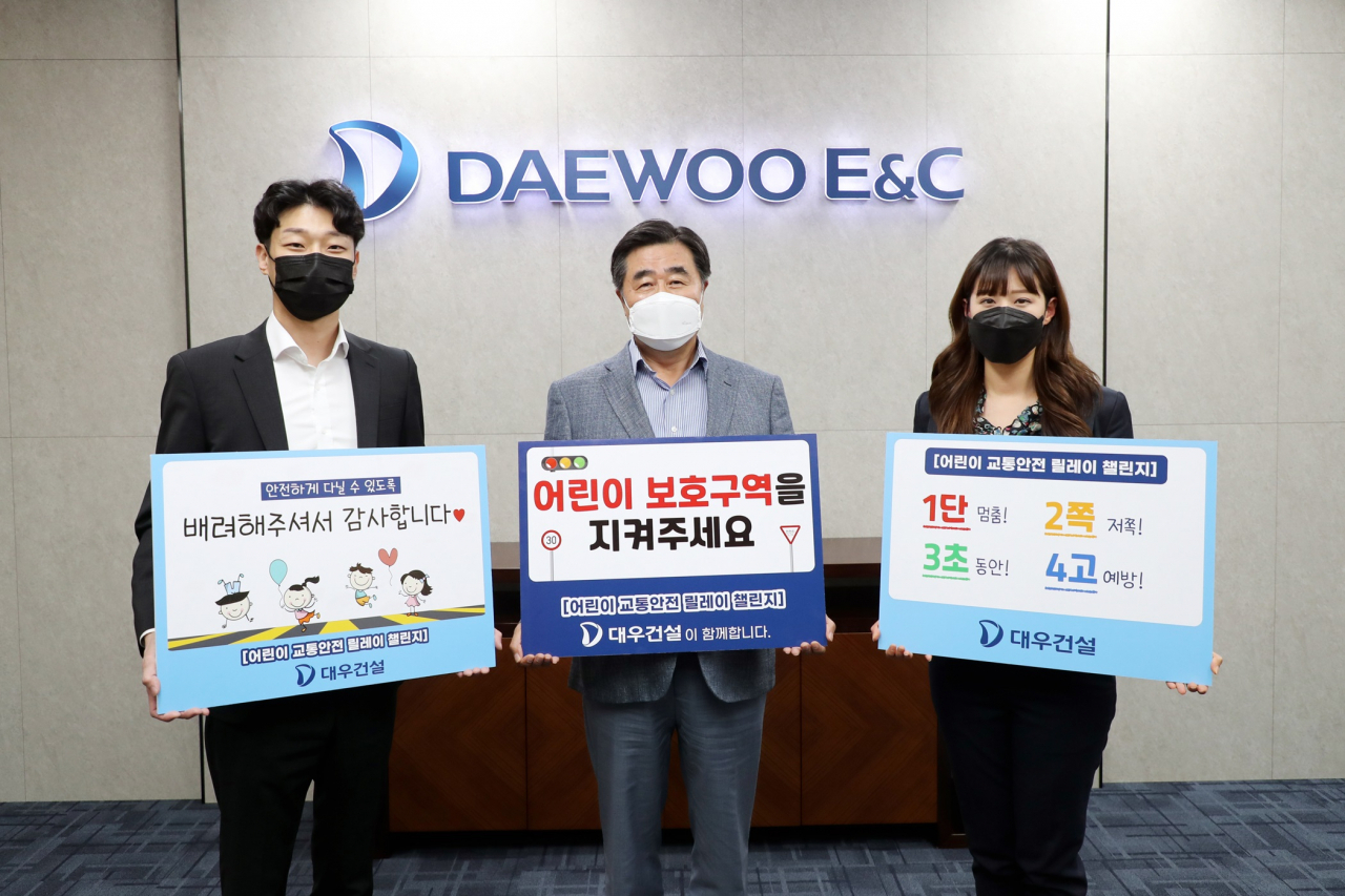 김형 대우건설 사장(가운데)과 직원들이 교통안전표어를 들고 있다. [대우건설 제공]