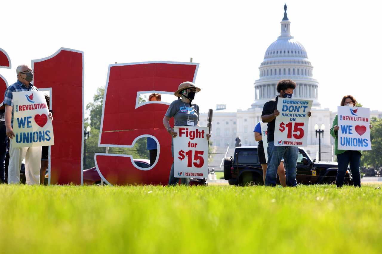 WASHINGTON, DC - MAY 19: Labor activists hold a rally in support of raising the minimum wage to $15 an hour on the National Mall on May 19, 2021 in Washington, DC. Members of the Service Employee International Union (SEIU) organized the rally in support of striking McDonald's workers who are demanding a wage increase. Kevin Dietsch/Getty Images/AFP == FOR NEWSPAPERS, INTERNET, TELCOS & TELEVISION USE ONLY ==