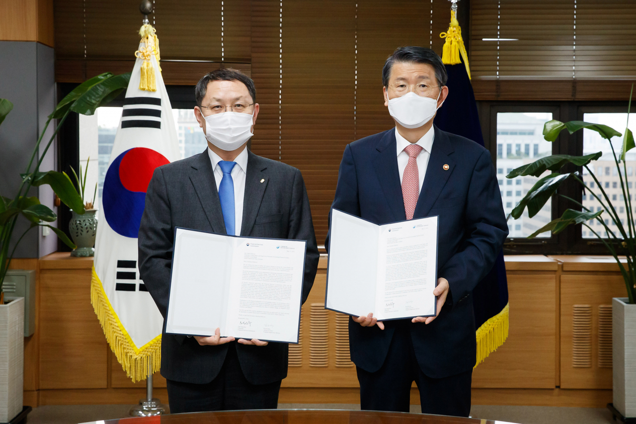은성수 금융위원장(오른쪽)과 김근익 금융감독원 수석부원장(왼쪽)이 17일 녹색금융협의체(NGFS) 가입 신청 서한에 서명을 하고 있다. [금융위원회 제공]