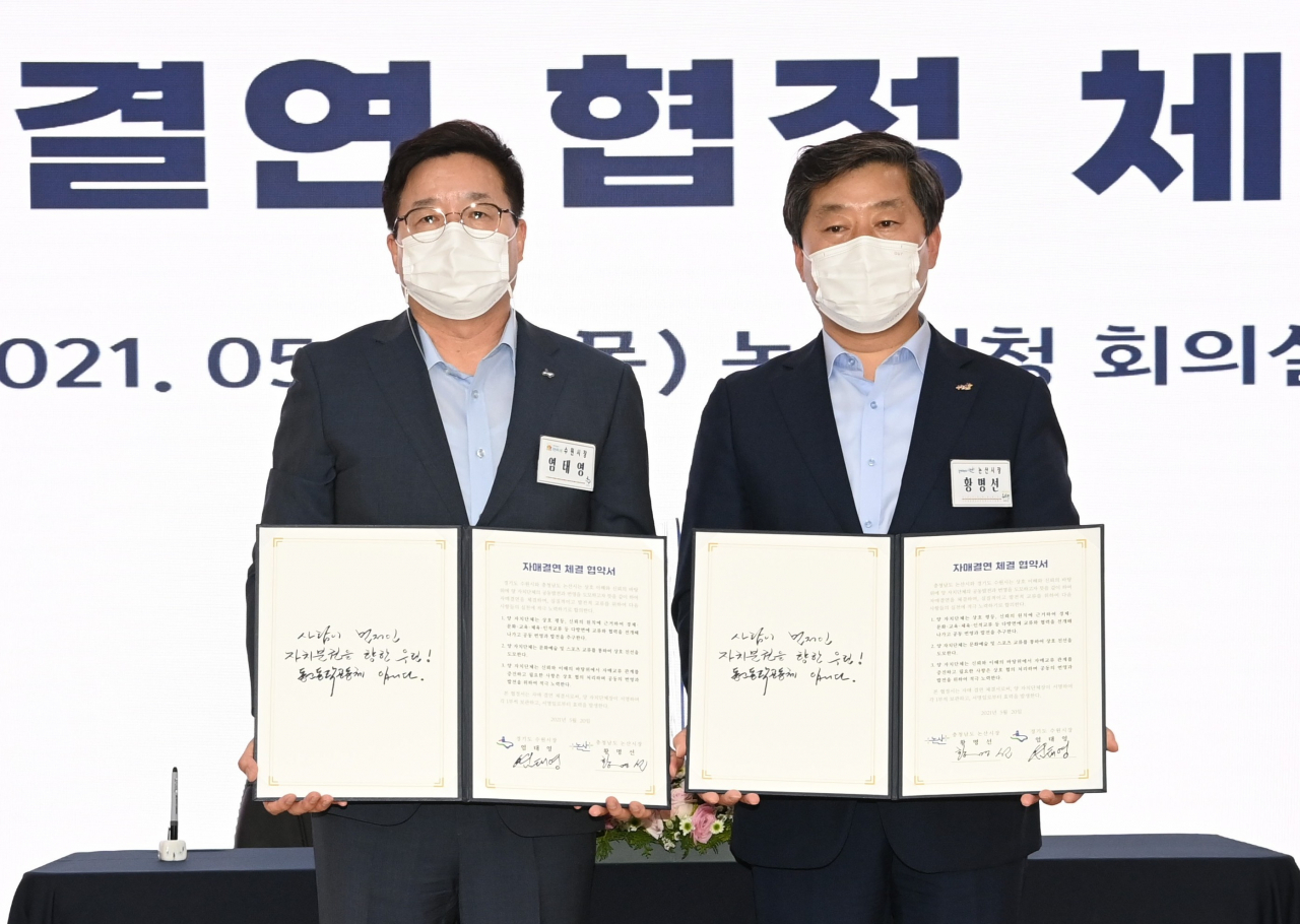 염태영 수원시장(왼쪽)과 황명선 논산시장이 협약서에 서명한 후 함께하고 있다.[수원시 제공]