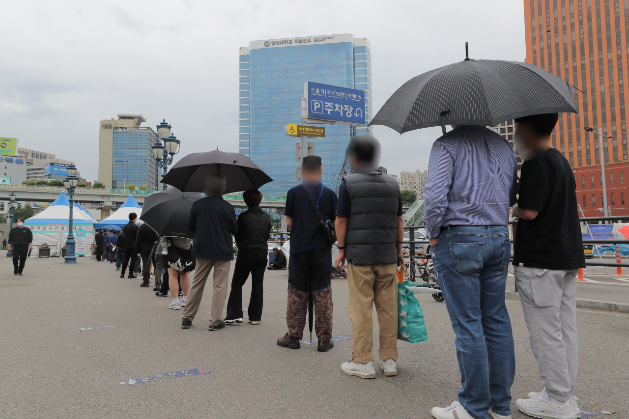 20일 오전 서울역광장에 마련된 임시선별진료소에서 시민들이 코로나19 검사를 받기 위해 줄을 서 있다. [연합뉴스]