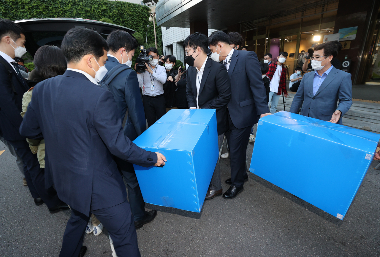 고위공직자범죄수사처 수사관들이 18일 오후 조희연 서울시교육감의 해직교사 부당 특별채용 의혹과 관련 서울시교육청 압수수색을 마친 뒤 박수를 들고 청사를 나서고 있다. [연합]
