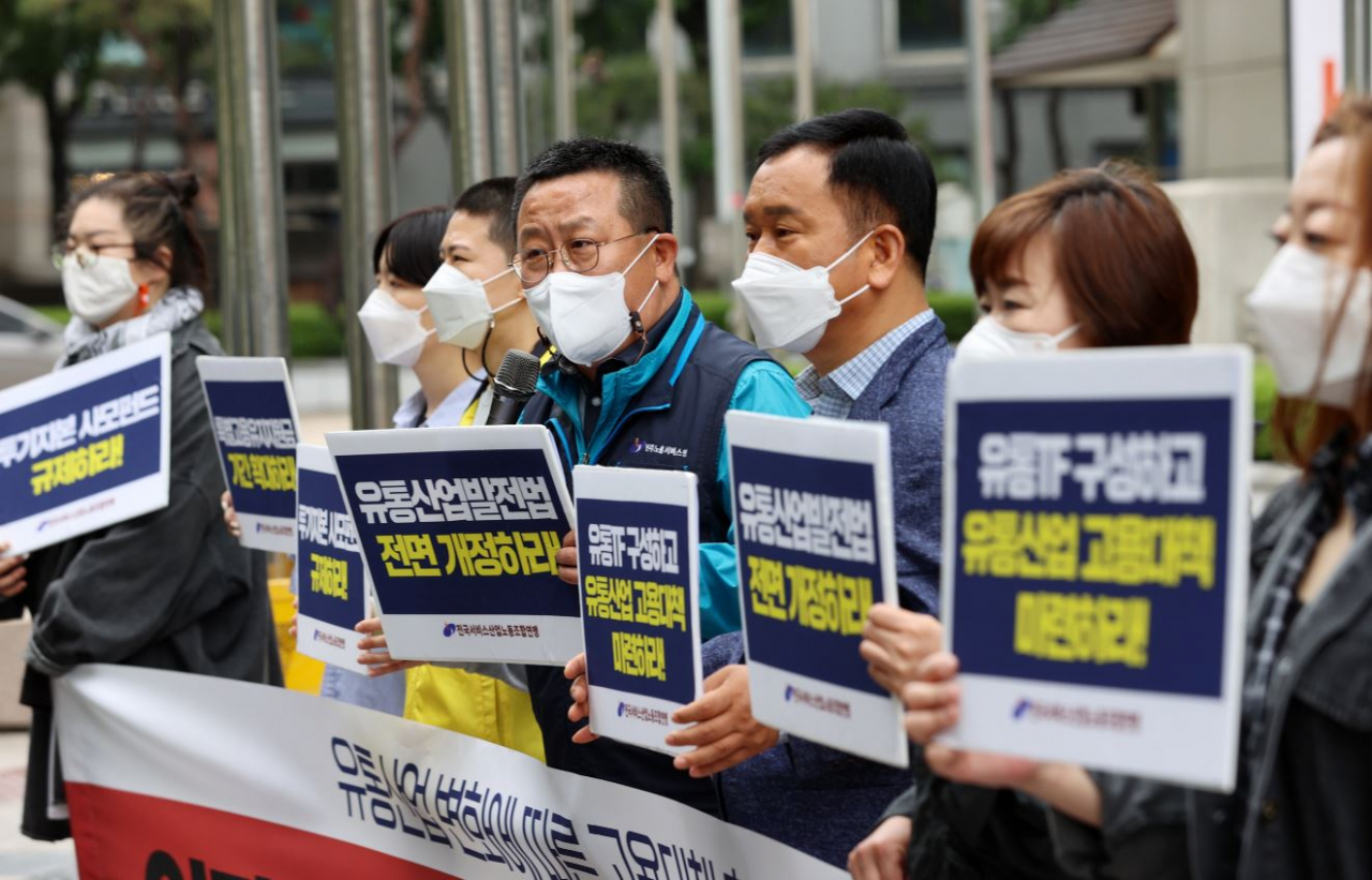 21일 오전 일자리위원회가 위치한 서울 종로구 kt광화문빌딩 앞에서 열린 '유통산업 변화에 따른 고용대책 촉구 기자회견'에서 전국서비스산업노동조합연맹 회원들이 유통TF 구성 등을 촉구하는 내용이 담긴 피켓을 들고 있다. [연합]