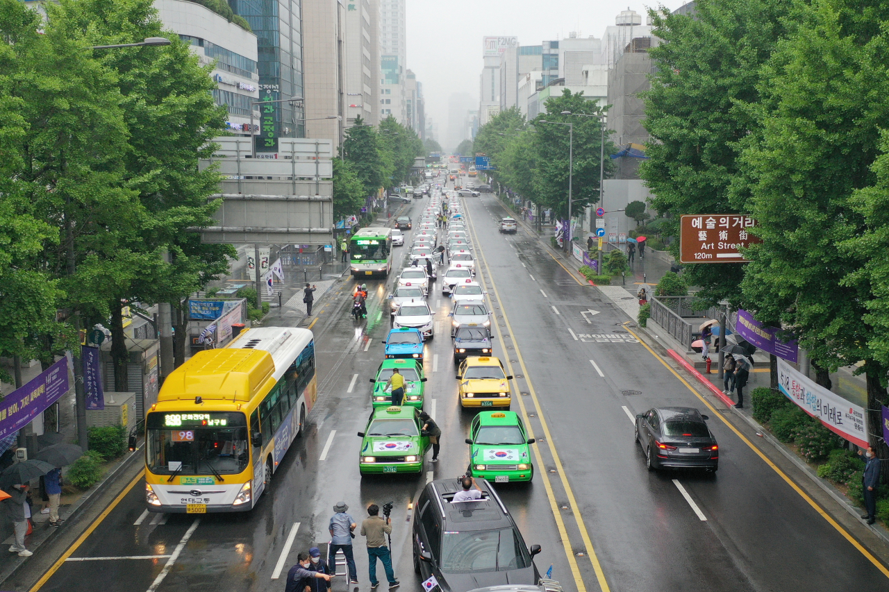 진보 성향의 교수단체들이 22일 “5월 광주가 불붙인 위대한 횃불은 꺼지지 않았다”며 정치·사회·경제 각 분야의 개혁을 촉구하는 시국선언을 했다. 지난 20일 오후 광주 동구 금남로에서 택시 기사들이 5·18 민주화운동 당시 차량 행진 시위를 재현하는 ‘민주기사의 날’ 행사를 여는 모습. [연합]