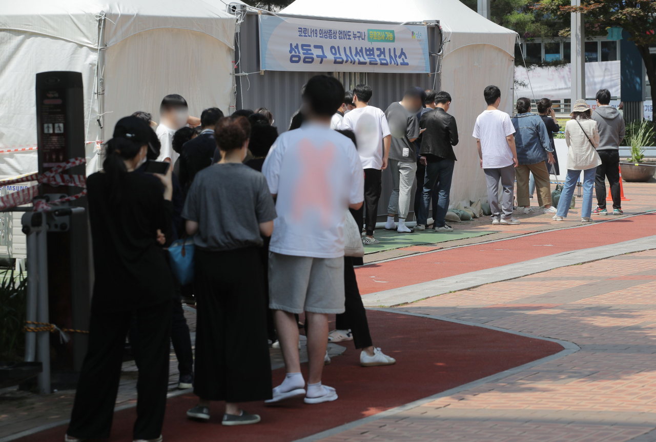 22일 서울 성동구 임시선별진료소에서 시민들이 코로나19 검사를 받기위해 줄을 서고 있다.[연합]
