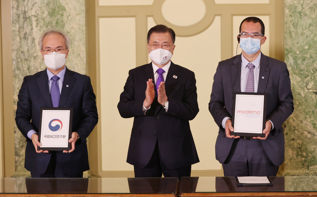 22일 오전(현지시간) 워싱턴 한 호텔에서 열린 '한미 백신 기업 파트너십 행사'에서 문재인 대통령이 참석한 가운데 백신 연구 개발 협력 MOU가 진행되고 있다. 왼쪽부터 권준욱 국립보건연구원장, 문 대통령, 스테판 반셀 모더나 CEO. [연합]