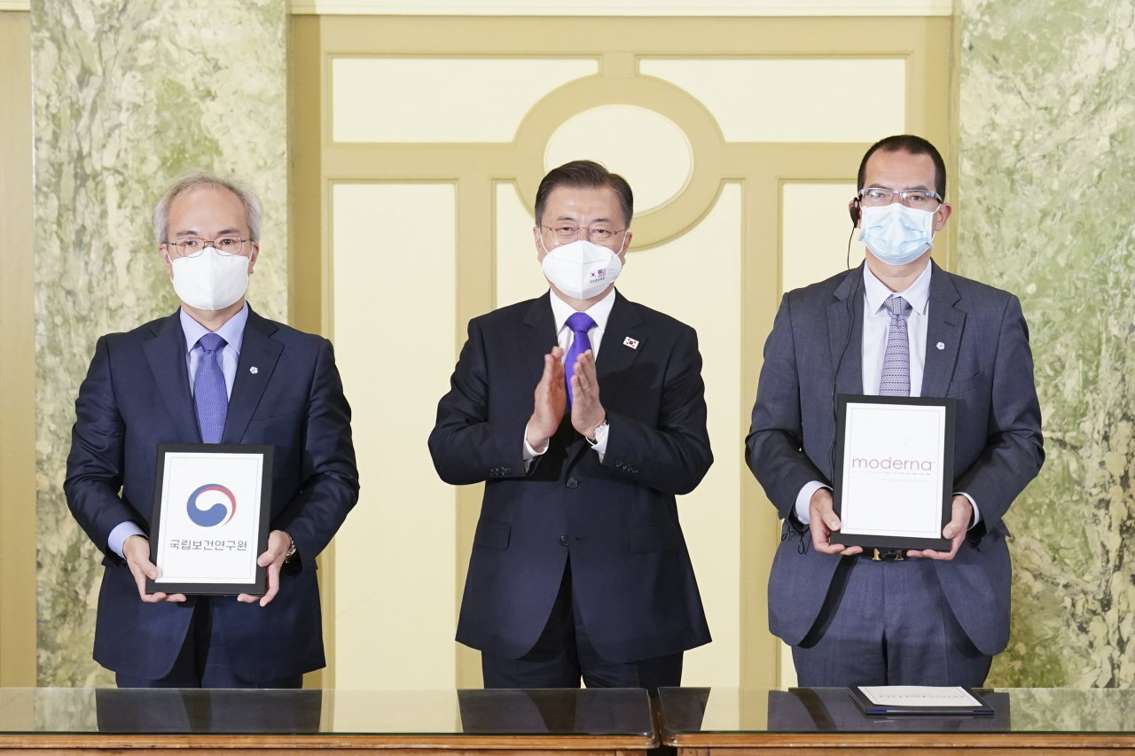 22일 오전(현지시간) 워싱턴 한 호텔에서 열린 '한미 백신 기업 파트너십 행사'에서 문재인 대통령이 참석한 가운데 백신 연구 개발 협력 MOU가 진행되고 있다. 왼쪽부터 권준욱 국립보건연구원장, 문 대통령, 스테판 반셀 모더나 CEO. 연합뉴스